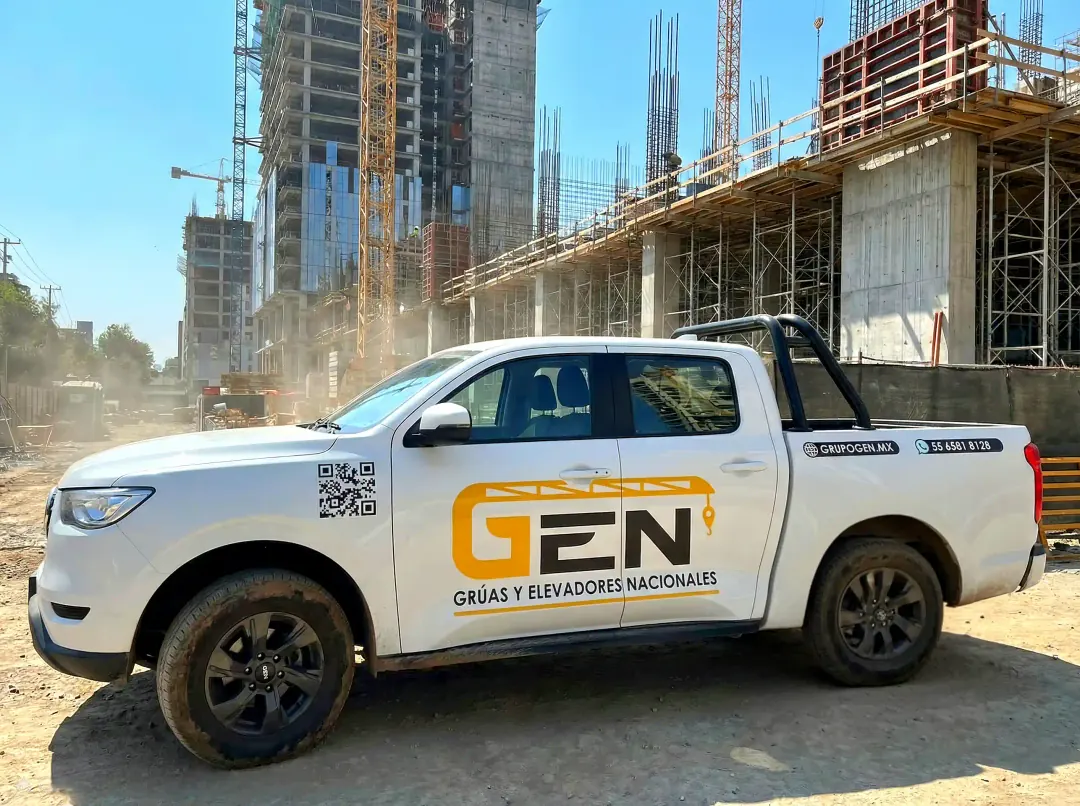 Ingeniero de GEN con casco revisando planos en obra junto a grúa torre